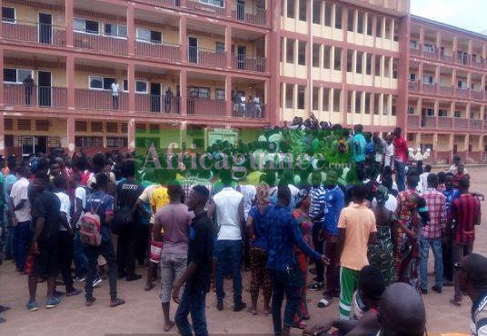 Des étudiants diplômés massés devant le bâtiment principal de l'Université de Kankan