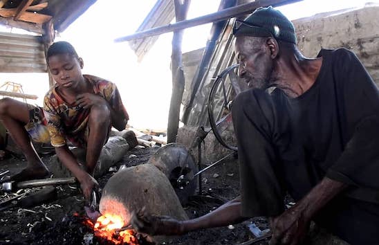 Mory Kanté dans sa forge avec un de ses apprentis