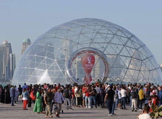 Des personnes rassemblées près de l'horloge marquant le compte à rebours avant la Coupe du monde de football, à Doha au Qatar, le 30 mars 2022, crédit photo AFP