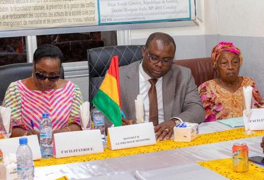 Dr Bernard Gomou, Premier ministre de la Transition guinéenne entouré deux facilitatrices